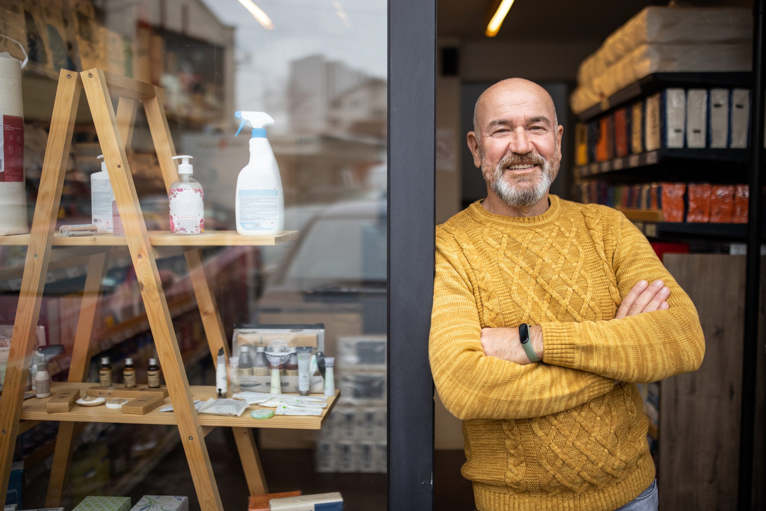 Proud owner standing with arms crossed in front of his store Proud owner standing with arms crossed in front of his store